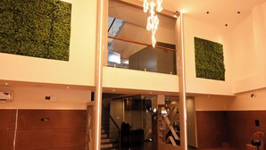 A modern interior with a glass elevator, a staircase, and a ceiling light fixture. - HOTEL SOUTH FOREST (Sulthan Bathery)