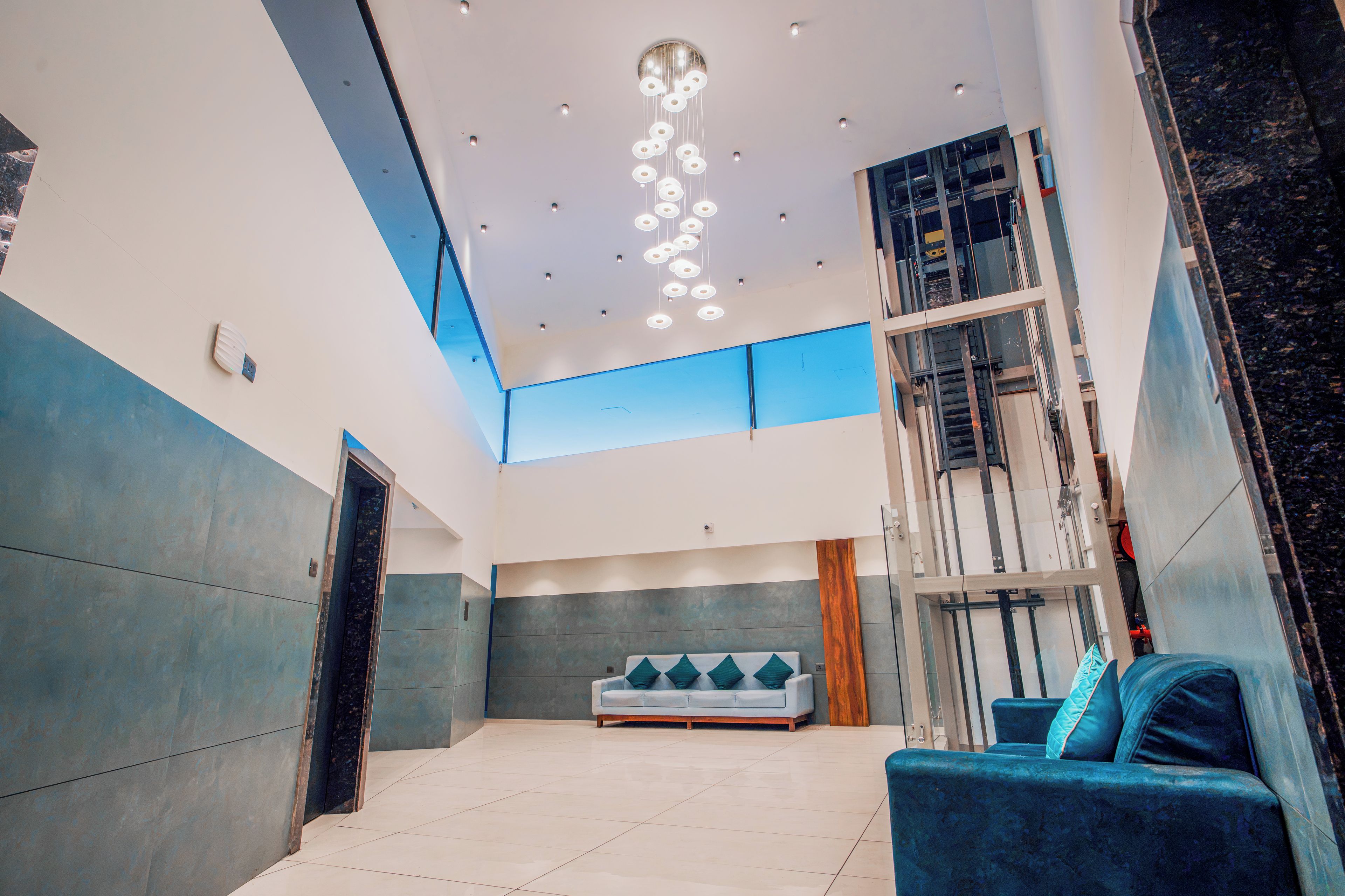 A spacious lobby with a high ceiling, a central seating area, and a staircase leading to upper floors.