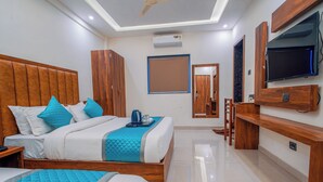 A modern hotel room with a large bed, a TV, and a minibar. - HOTEL SOUTH FOREST (Sulthan Bathery)
