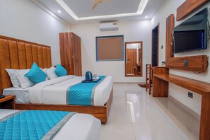 A modern hotel room with a large bed, a TV, and a minibar. - HOTEL SOUTH FOREST (Sulthan Bathery)