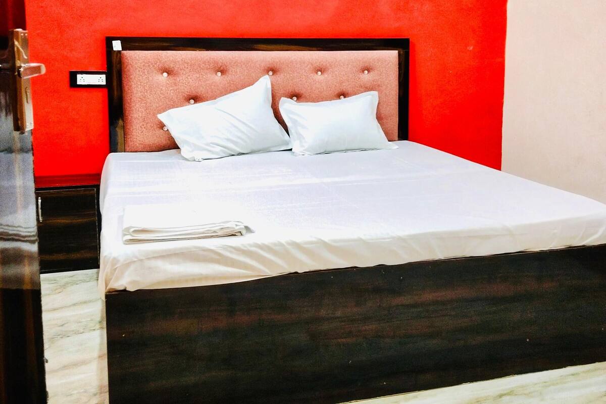 Uma cama com roupa de cama branca, cabeceira estofada e chão de mármore.