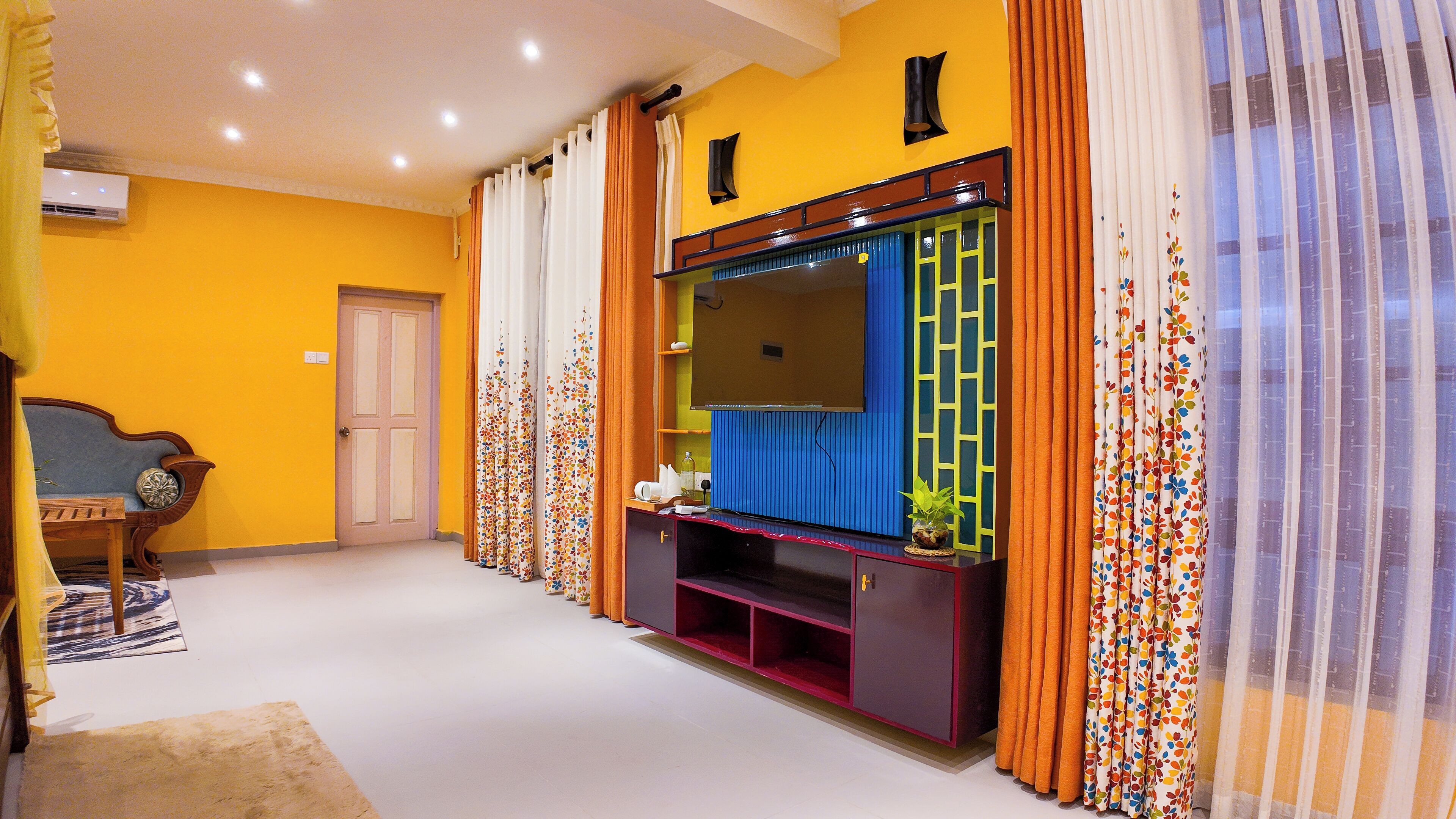 Una sala de estar con un mueble grande para entretenimiento, una puerta y un banco.