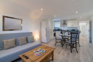 Eine moderne Wohnung mit Wohnzimmer, Essbereich und Küche.