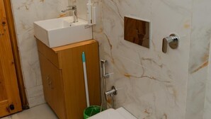 A bathroom with a toilet, sink, mirror, and towel rack. - The Meemos Cafe And Cottages (Mussoorie)