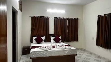 A bedroom with a bed, curtains, a ceiling fan, and a tiled floor.