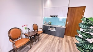 Une cuisine compacte avec un coin repas, comprenant une table et des chaises en bois, une cuisinière intégrée et un évier.