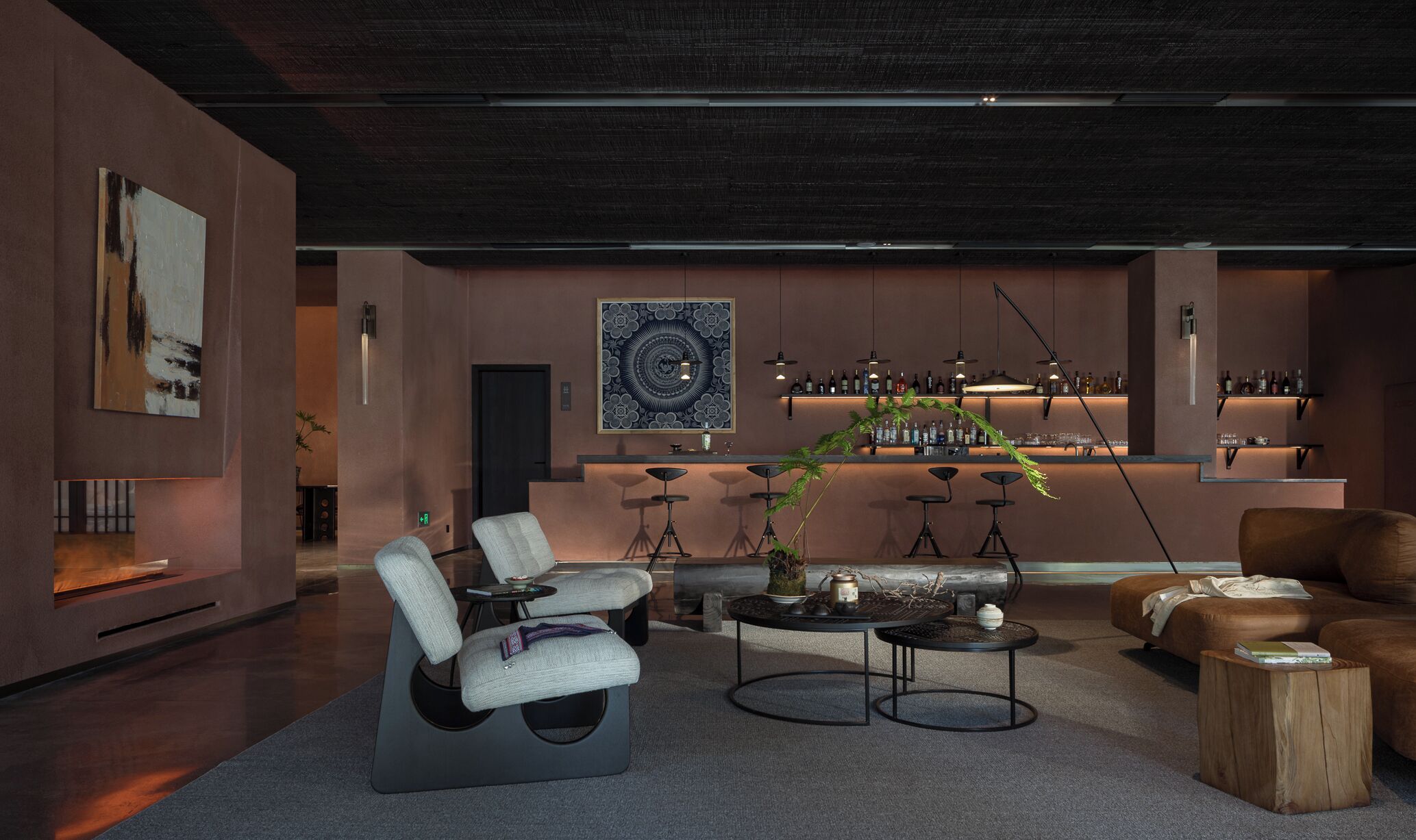 A modern living room with a bar area, featuring a sofa, armchairs, and a coffee table.