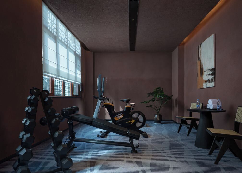 A gym with exercise equipment, a treadmill, and a large window with blinds.