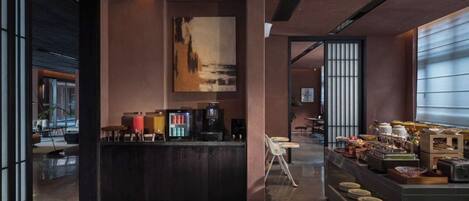 A modern interior with a central bar area, seating, and a buffet setup.