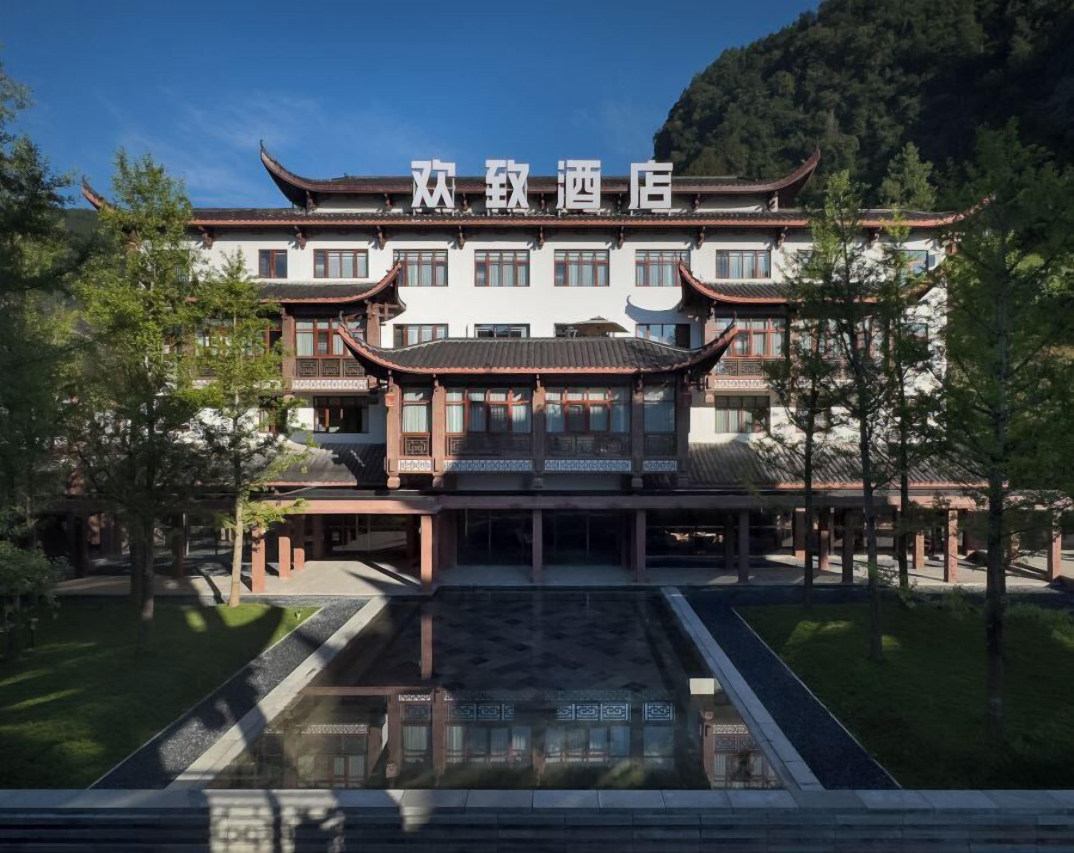 Un edificio chino tradicional con fachada simétrica, numerosas ventanas y una entrada central.