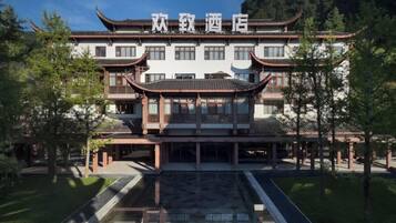 Un edificio chino tradicional con fachada simétrica, numerosas ventanas y una entrada central.