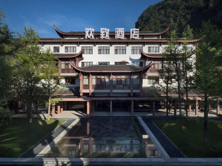 Un edificio chino tradicional con fachada simétrica, numerosas ventanas y una entrada central.