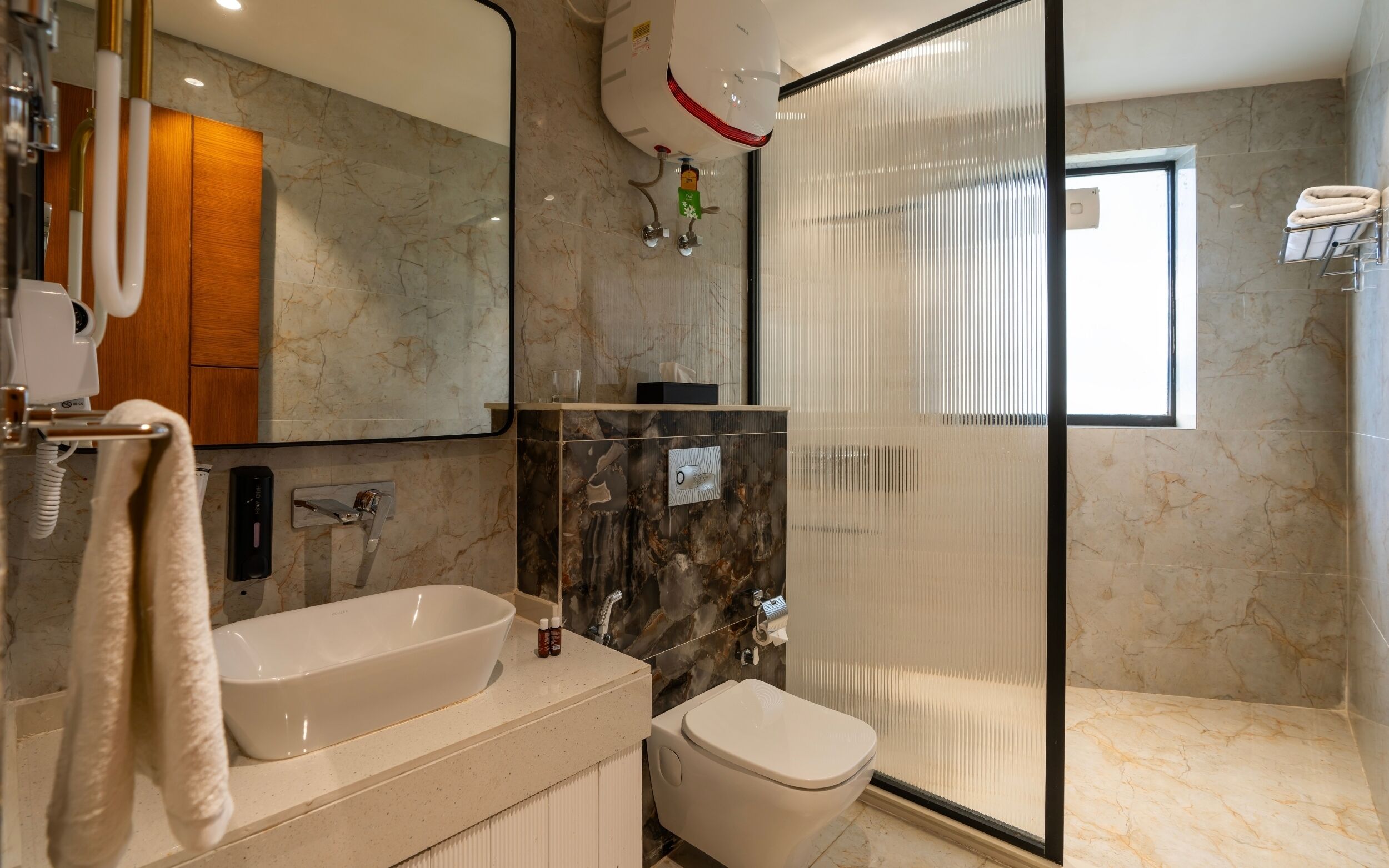 Een moderne badkamer met bad, toilet en douchecabine van glas.