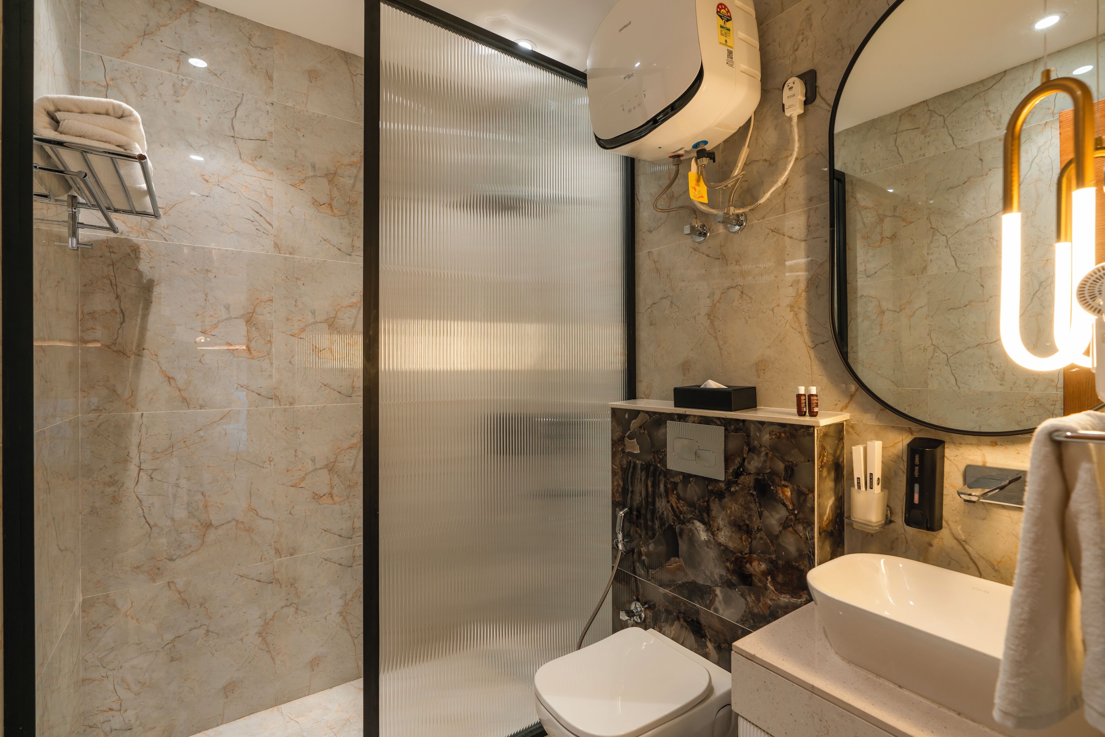 Une salle de bain moderne avec une douche à parois de verre, des toilettes, un lavabo et un miroir.