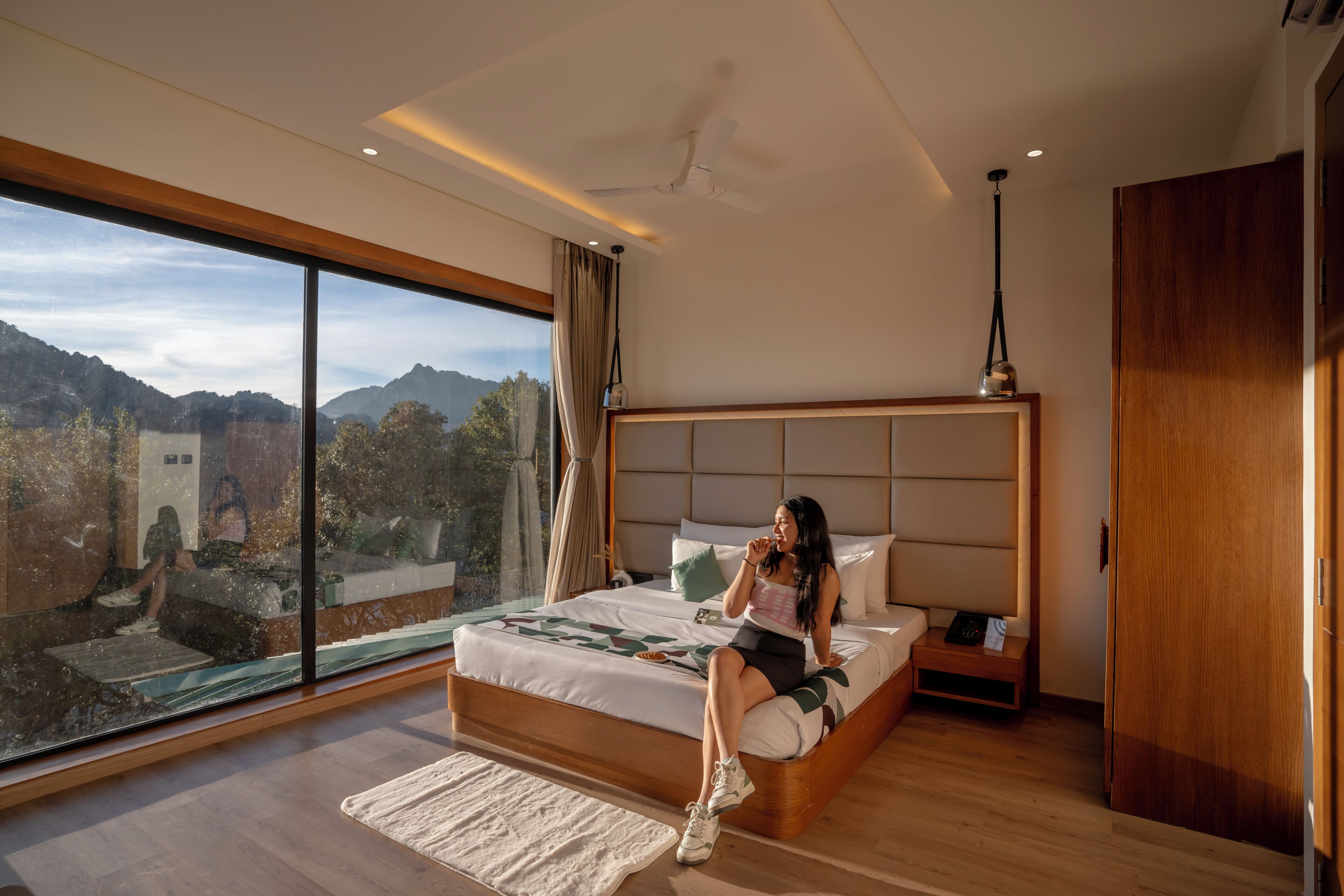 Un dormitorio moderno con una cama grande, una mesita de noche y vistas al exterior.