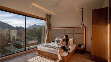 Un dormitorio moderno con una cama grande, una mesita de noche y vistas al exterior.