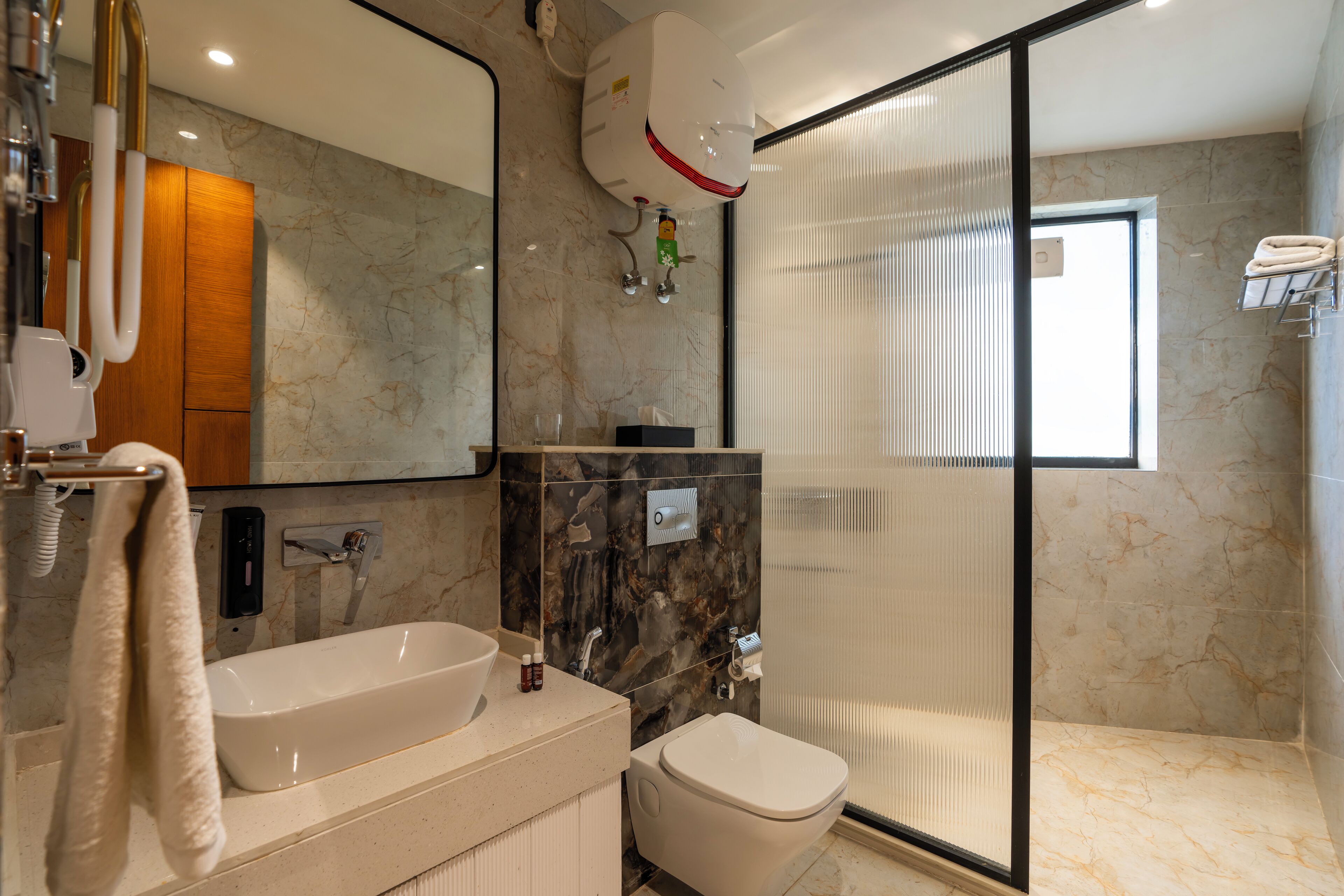 A modern bathroom with a bathtub, toilet, and a glass-enclosed shower.