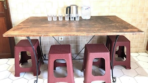 A kitchen with a tiled backsplash, a wooden table, four stools, and kitchenware. - Chinese guesthouses in Casablanca (Casablanca)