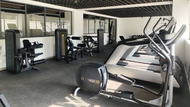 A gym with cardio equipment, weight machines, and a mirrored wall. - The Loftel Ruaka (Ruaka)