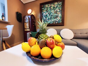 A fruit bowl on a table with a painting and a vintage radio in the background. - The best location in Santa Pola! Apartment next to the beach surrounded by stores. (Santa Pola)