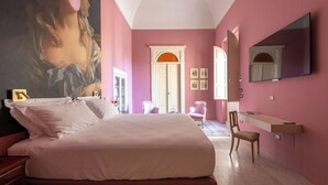 A bedroom with a large bed, a vanity with a mirror, and a door leading to another room. - Bubble Apartment - Villani Lubelli (Cannole)