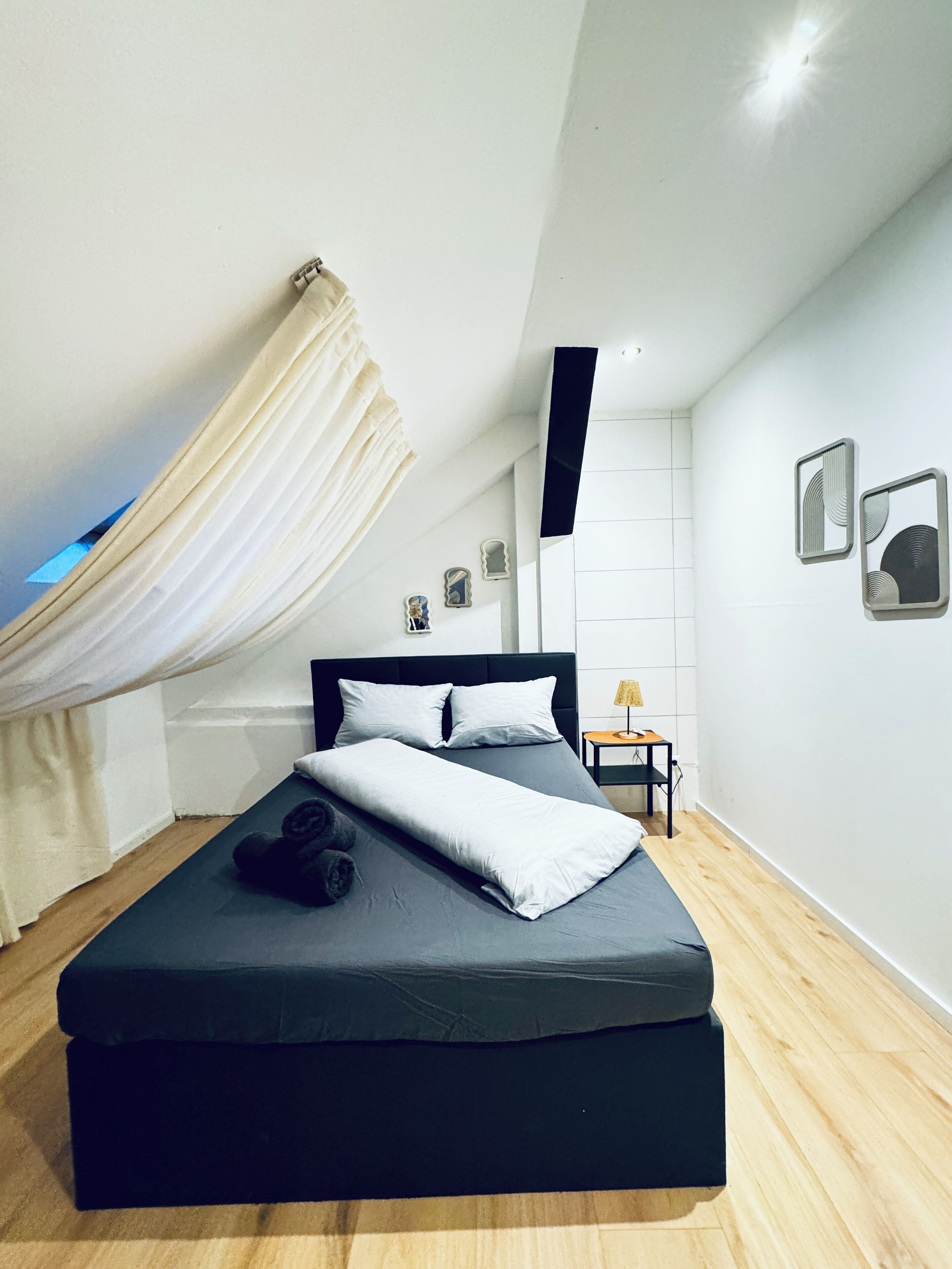 Ein modernes Schlafzimmer mit einem Bett, einem kleinen Tisch und einem Stuhl.