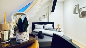 Un dormitorio moderno con cama, mesita de noche y una silla.