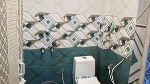 Ένα μπάνιο με τουαλέτα, ντους και νιπτήρα.