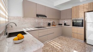 A modern kitchen with a marble countertop, a built-in oven, and a coffee maker. - Casa Centrale by Nomads (Paphos)