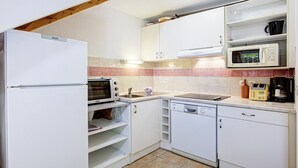 A compact kitchen with white cabinets, a microwave, a toaster, and a dishwasher. - Family Villa Near Lac de Jouarres (Homps)