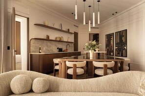 A modern dining area with a marble countertop, wooden chairs, and pendant lighting. - Luxury A/C Apt - 6P/3BDR - Arc de Triomphe (Paris)