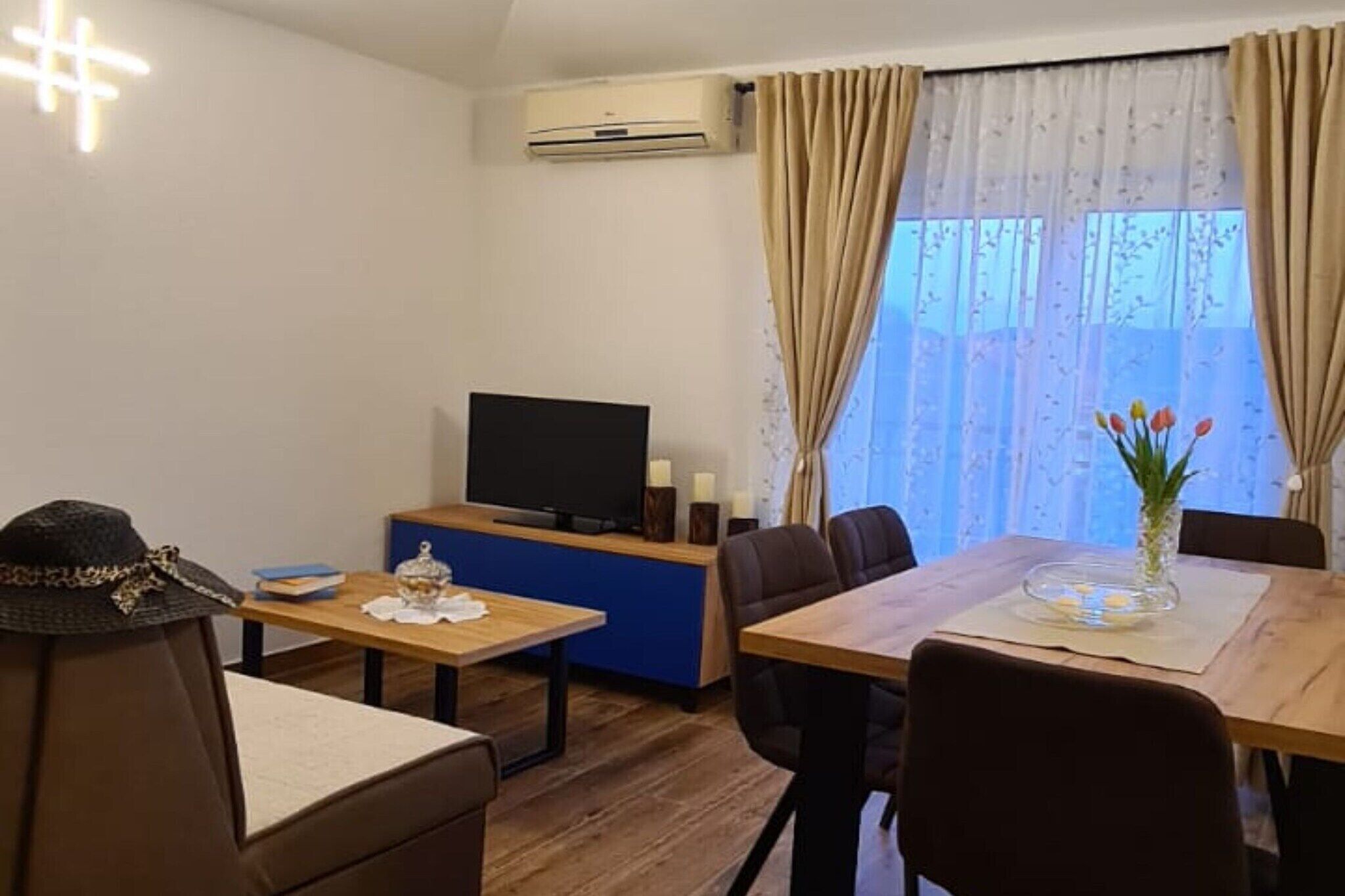 A living room with a television, a dining table, and a sofa.