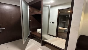 Un baño con una puerta de madera oscura, un espejo, un inodoro y una zona de ducha.