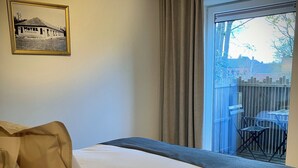 A hotel room with a bed, a window with a view of the outside, a framed picture on the wall, and a curtain. - Li Ter Hôtel&Restaurant (Marche-en-Famenne)