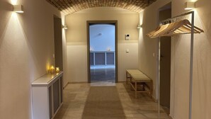 A hallway with a brick ceiling, a bench, a coat rack, and a view of a balcony. - Family- & dog-friendly apartment near the Elbe with direct access to the park (Dresden)