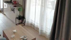 Uma cozinha moderna com armários brancos, bancada preta e luminária pendente.