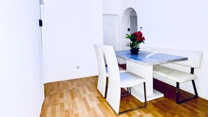 A dining area with a table and chairs, a potted plant, and a ceiling light fixture. - Budget Friendly 4 BR Apt for Groups (Vienna)