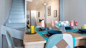 A dining area with a wooden table, chairs, and a staircase leading to another room. - House T3 Gaillac Centre-Cosy-Netflix-Parking (Gaillac)
