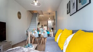 A modern living room with a sofa, TV, and dining area. - House T3 Gaillac Centre-Cosy-Netflix-Parking (Gaillac)