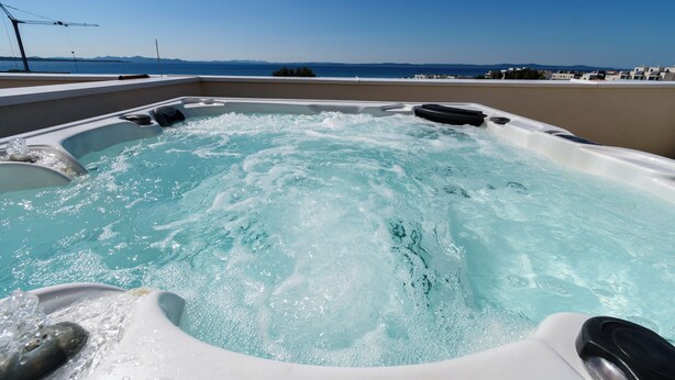 A hot tub with a view of the sea and buildings in the background. - Spacious 5-bedroom villa in serene Privlaka with all year swimming pool (Privlaka)