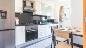 A modern kitchen with a stove, oven, and water dispenser.