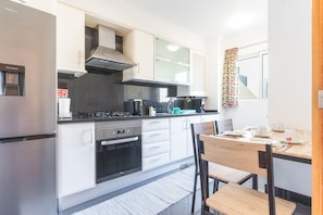 A modern kitchen with a stove, oven, and water dispenser. - Judite Home Apartment by Atlantic Holiday (Santa Cruz)