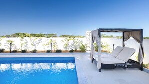 A poolside area with a canopy and a reclining chair. - Cozy 2-bedroom apartment in adorable Wailoaloa Beach (Nadi)