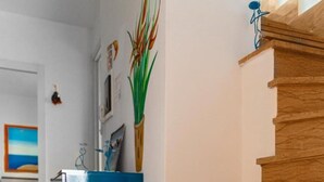 A modern interior with a wooden staircase, a blue cabinet, and a wooden floor. - La Terrazza sul Porto B&B (San Foca)