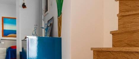 A modern interior with a wooden staircase, a blue cabinet, and a wooden floor.