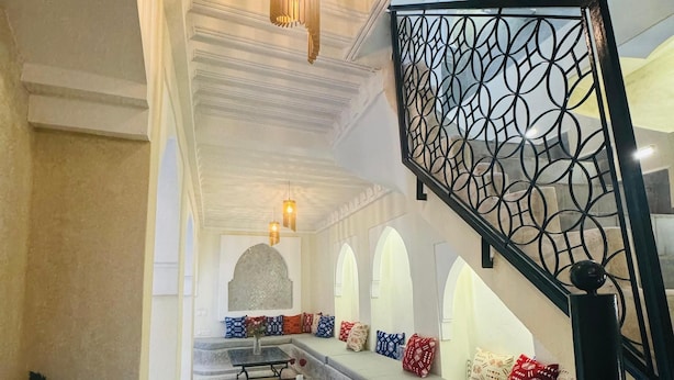 A spacious lobby with a central seating area, a staircase with decorative railings, and a patterned floor. - Riad Blue Berry (Marrakech)