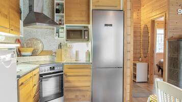 Een moderne keuken met een roestvrijstalen koelkast, een ingebouwde oven, een magnetron en houten keukenkastjes.