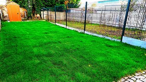 A well-maintained lawn with a stone pathway leading to a fence. - Le Logis du Jardin Anzin (Anzin)