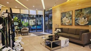 Un vestíbulo moderno con un sofá, una mesa de centro y una puerta de cristal que da a una zona de piscina.