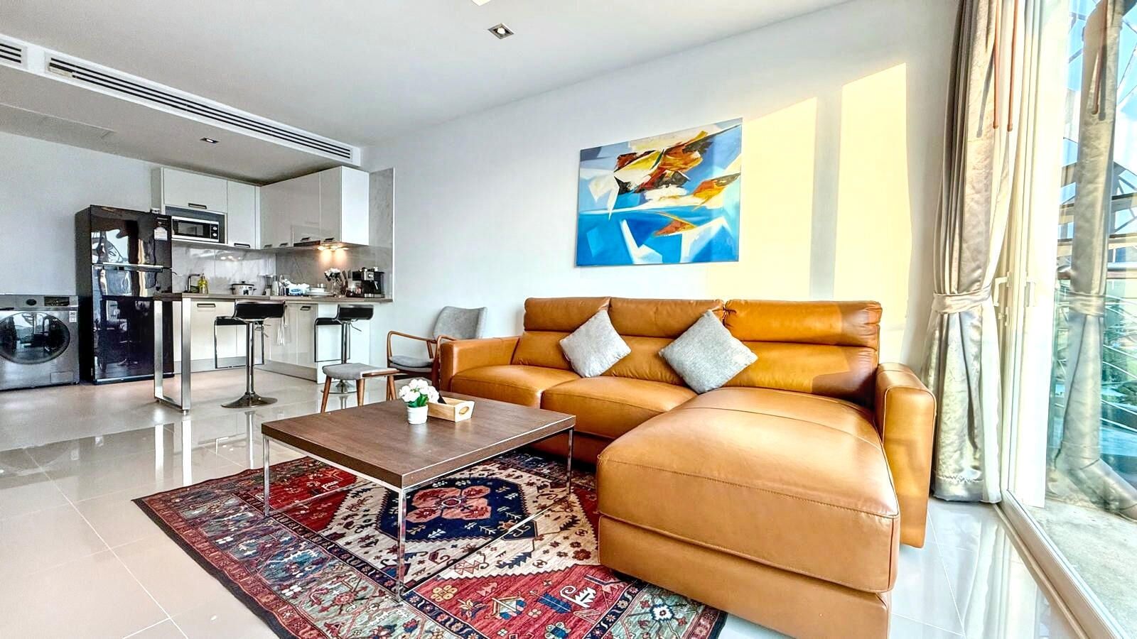 A modern living room with a sofa, coffee table, and a rug.
